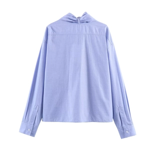 Camicia a maniche lunghe azzurra da donna con dettaglio carré posteriore su sfondo bianco