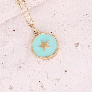 Macro view of gold necklace featuring star charm on light blue enamel coin pendant