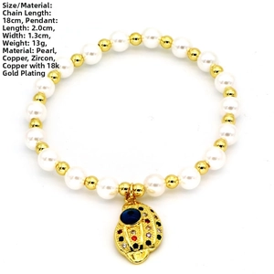 Detailansicht eines 18K vergoldeten Fischanhängers am Perlenarmband mit Zirkonia-Steinen