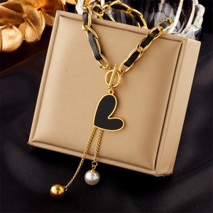 Golden chain necklace with black leather weave, black heart pendant and pearl tassel detail