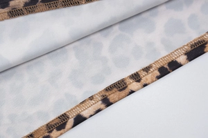 Dettaglio del tessuto con stampa leopardata e cuciture overlock di alta qualità sul vestito