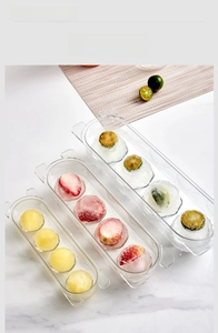 Detail of clear sphere ice molds on marble surface with lemon and strawberry ice balls