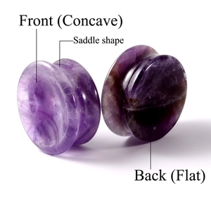 Macro detail of saddle shape amethyst ear plugs showing concave front and flat back