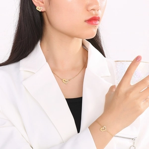 Set di gioielli dorati con cuori asimmetrici e diamanti, inclusi collana ed orecchini
