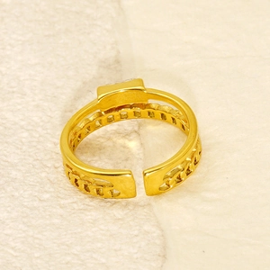 Macro shot of gold-plated open ring featuring chain texture and rectangular geometric element