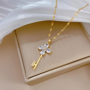 Elegant gold titanium steel key necklace featuring a sparkling clover flower crystal pendant