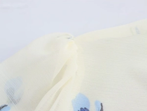Macro dettagliata del tessuto in chiffon floreale con cuciture e trama a spalla plissettata