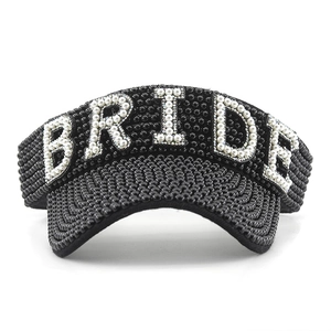 Detail of black sun visor with rhinestones and white pearl BRIDE lettering for women