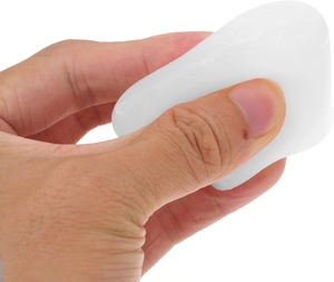 Close-up of a hand holding a white translucent silicone mold for pumpkin candle making