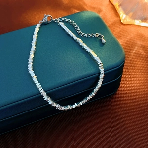 Detail shot of silver geometric bead bracelet with lobster clasp on jewelry box