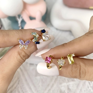 Hand holding 18k gold butterfly earrings with colorful zircon gemstones for women