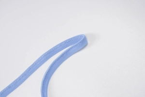 Macro view of light blue dress strap featuring fine woven texture and zigzag stitching details