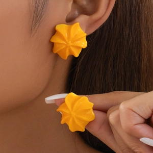 Orecchini a forma di biscotto giallo indossati da una modella in uno stile di moda creativo