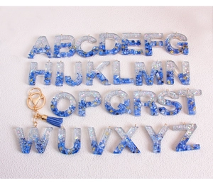 Glitter blue resin alphabet keychain set with tassels and gold celestial inserts