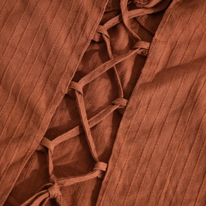 Dettaglio del top a lupetto color terracotta con trama a righe e lacci incrociati