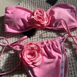 Detail of pink bikini with 3D rose flower applique on strapless top and side-tie bottom
