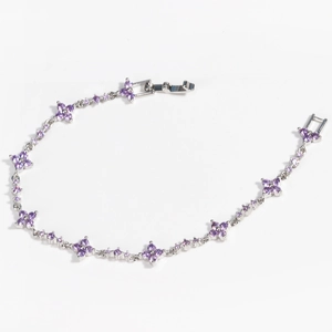 Detail of silver clover bracelet featuring purple zircon flowers and folding clasp