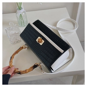Detail of the crocodile texture handbag with bamboo handle and gold square clasp
