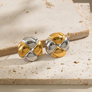 Polished gold and silver two-tone woven knot stud earrings on stone platform