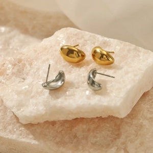 Polished 18K gold and silver plated stainless steel bean earrings on pink mineral stone