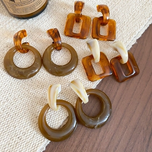 Close-up of vintage resin geometric drop earrings in amber and olive green on fabric