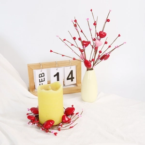 Valentine's Day candle ring with red heart berries and yellow LED pillar candle