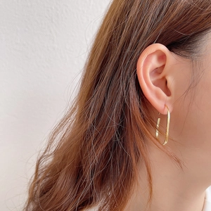 Classic 925 sterling silver U-shaped gold hoop earrings on female model with soft lighting