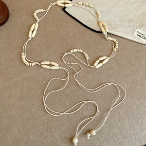 Detail of handcrafted cream acrylic and wood bead waist chain belt with vintage ethnic style