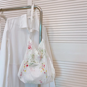 Close-up of cotton tote bag featuring colorful floral patterns and plumetis texture