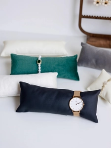 Close-up of assorted velvet and leather watch display pillows for jewelry presentation