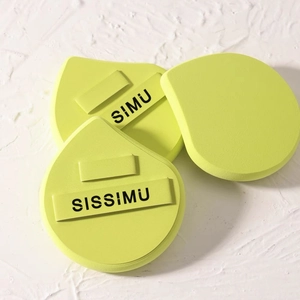 Three neon yellow and green makeup sponges set on a textured white background