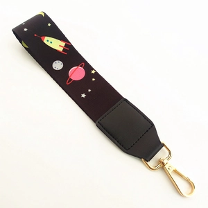 Space theme strap with rocket and planet patterns on black fabric with gold metal clasp