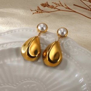 French vintage 18K gold titanium steel drop earrings with white pearls on ceramic dish