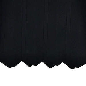 Close-up of black ribbed knit fabric featuring a decorative wavy scalloped hem detail