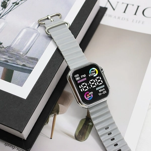 Gray sporty LED watch with silver metal case and wavy silicone strap on a lifestyle background