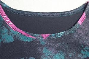 Macro view of the elegant printed mesh round neckline and meticulous stitching details