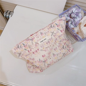 Close-up of floral print cotton makeup pouch with simple wish label and soft texture