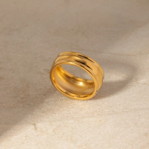 Minimalistischer 18k vergoldeter Edelstahlring mit Strass auf einem Steinuntergrund