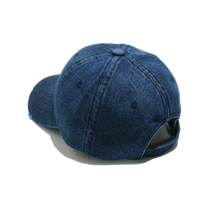 Detail of blue denim baseball cap with distressed brim and adjustable rear metal buckle