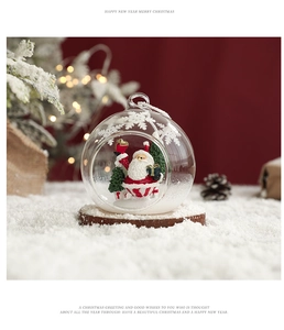 Macro detail of clear glass Christmas ball featuring Santa Claus and a miniature tree