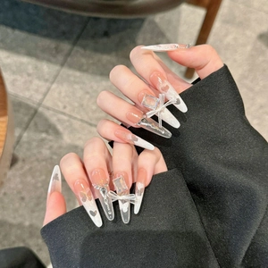 Stiletto press-on nails featuring butterfly accents and pink blush gradient design