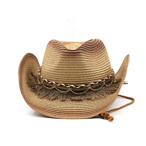 Detail of straw cowboy hat with fringe tassels, metal chains, and adjustable chin cord