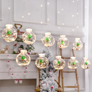 Hanging Christmas wish ball lights with miniature trees and warm LED glow for holiday decor