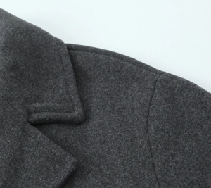 Gros plan sur le col et les coutures d'épaule d'un manteau en laine gris foncé épais