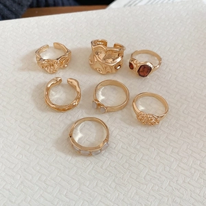 Detailed top view of 7-piece gold ring set with amber stones and textured resin details