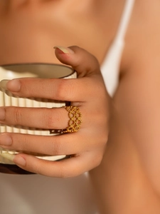 Detail of a gold honeycomb hollow-out ring with delicate bead-woven texture on model