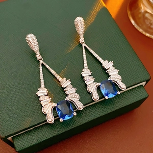 Detailed macro view of vintage sapphire blue zircon drop earrings with pavé crystal wings