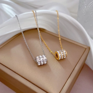 Elegant gold and silver titanium steel cylinder necklaces on luxury gift box with silk