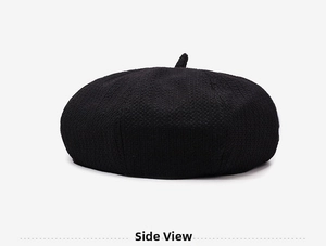 Side view of black knitted beret hat showing texture and structured pumpkin cap shape