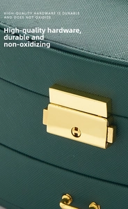 Close-up of luxury dark green cross-grain leather jewelry box with gold metal H-lock